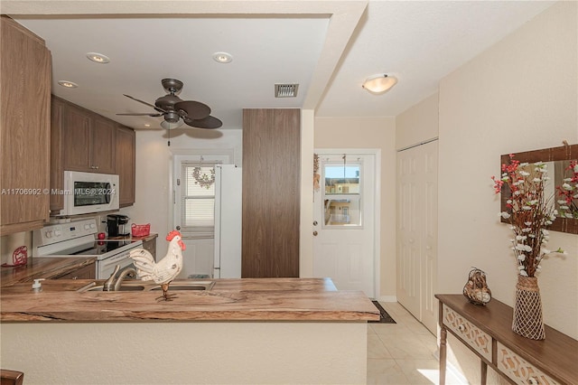 kitchen with kitchen peninsula, white appliances, ceiling fan, and sink