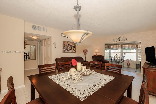 dining room featuring light tile patterned flooring and a textured ceiling