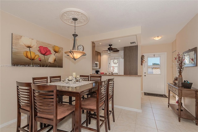 tiled dining room featuring a textured ceiling and ceiling fan