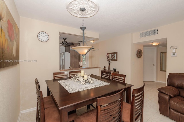 dining room with ceiling fan, light tile patterned floors, and a textured ceiling