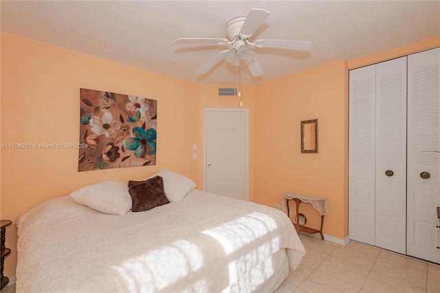 tiled bedroom with ceiling fan and a closet