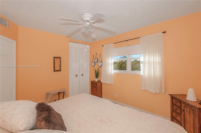 carpeted bedroom featuring ceiling fan and a closet