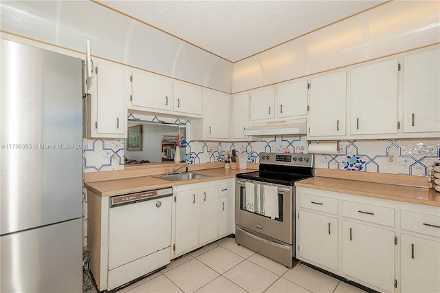 kitchen with white cabinets, light tile patterned flooring, a textured ceiling, and appliances with stainless steel finishes