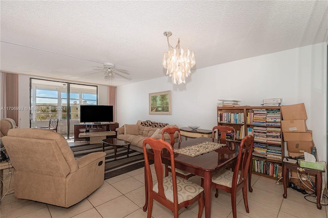 dining area featuring a textured ceiling, ceiling fan with notable chandelier, and light tile patterned floors