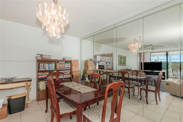 dining area with a textured ceiling, ceiling fan with notable chandelier, and light tile patterned floors