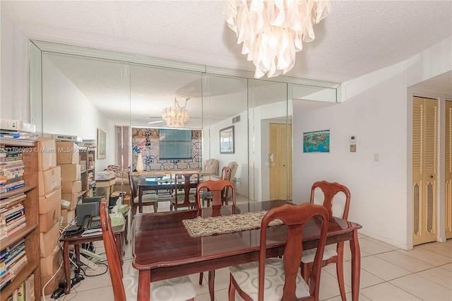 tiled dining room with a textured ceiling and a notable chandelier