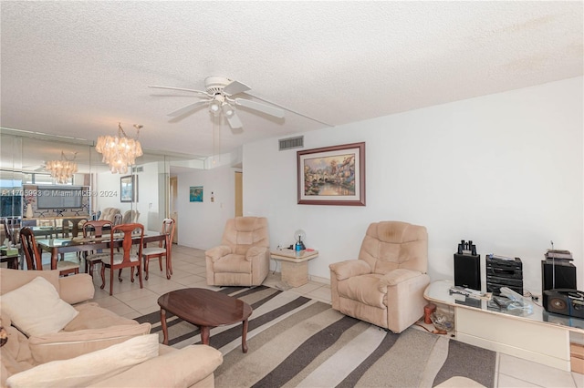 living room featuring a textured ceiling, light tile patterned floors, and ceiling fan with notable chandelier