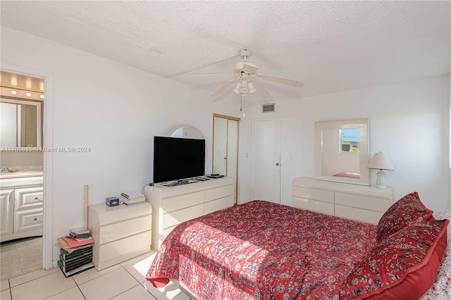 bedroom featuring ensuite bath, tile patterned floors, a textured ceiling, ceiling fan, and sink