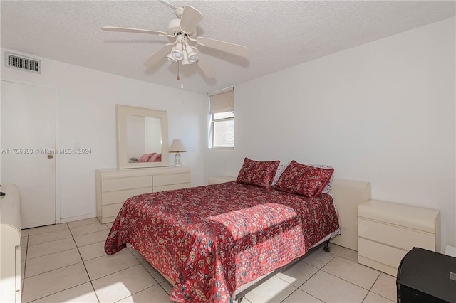 bedroom with light tile patterned floors, a textured ceiling, and ceiling fan