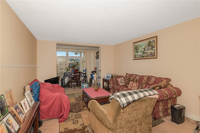 living room with ceiling fan, light colored carpet, and a textured ceiling