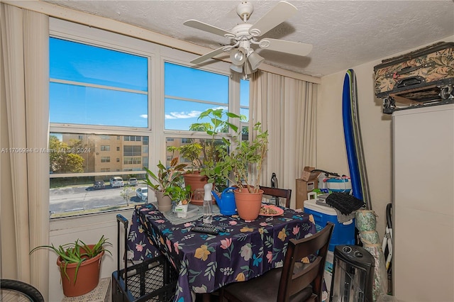 dining room featuring ceiling fan and a textured ceiling