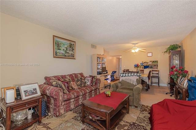 living room featuring a textured ceiling, light colored carpet, and ceiling fan