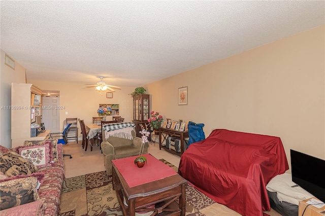 carpeted living room with ceiling fan and a textured ceiling