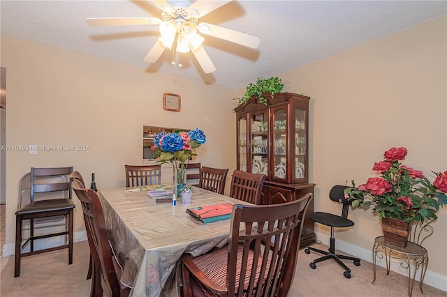 carpeted dining room featuring a textured ceiling and ceiling fan