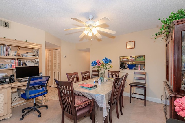 carpeted dining room featuring a textured ceiling and ceiling fan