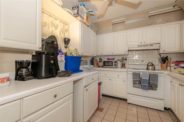 kitchen featuring white range with electric stovetop, tasteful backsplash, white cabinets, and light tile patterned floors