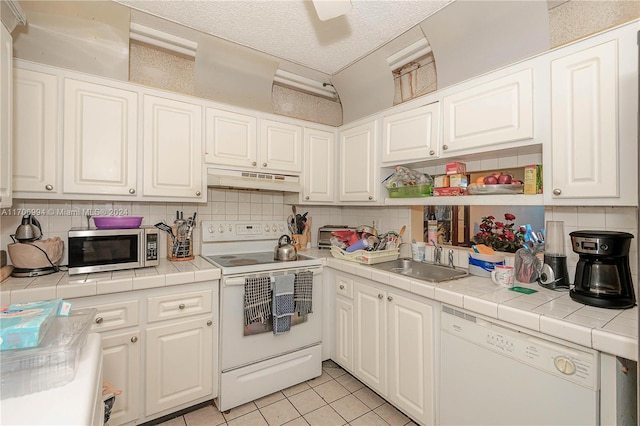 kitchen featuring electric stove, dishwasher, tile counters, and sink