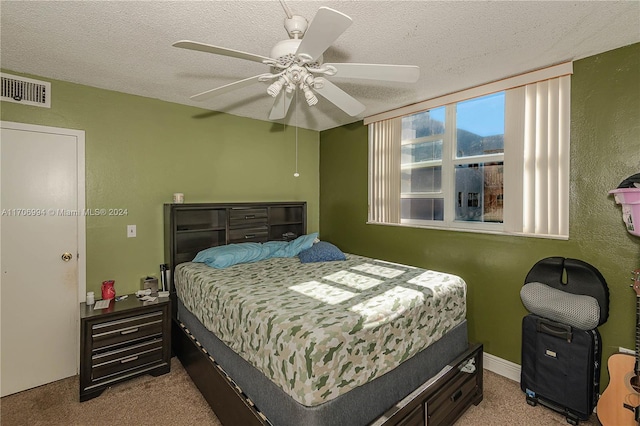 carpeted bedroom with ceiling fan and a textured ceiling