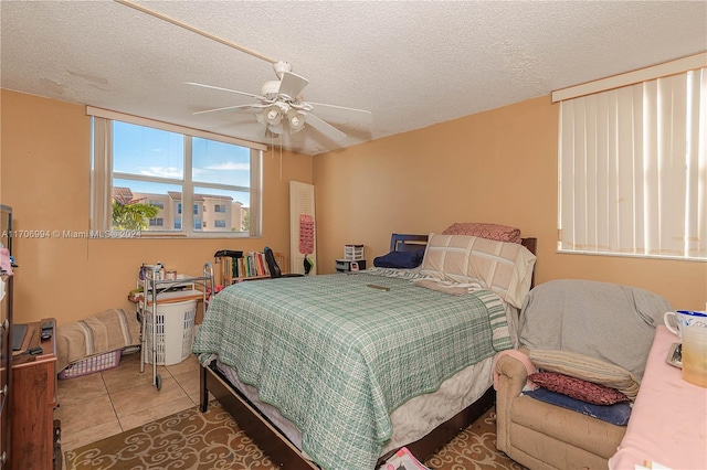 tiled bedroom featuring ceiling fan and a textured ceiling