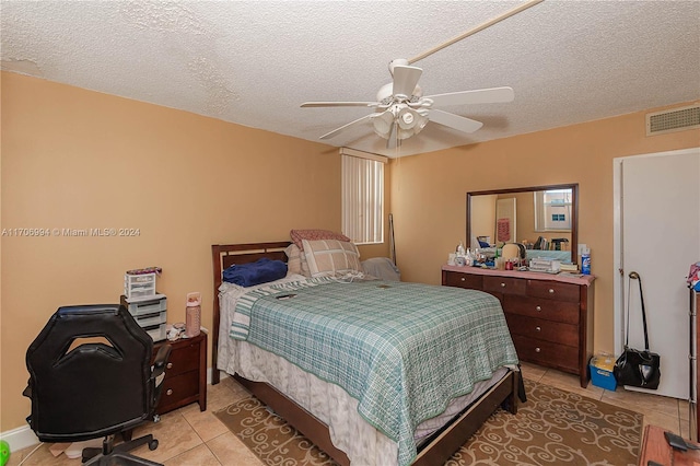 tiled bedroom with a textured ceiling and ceiling fan