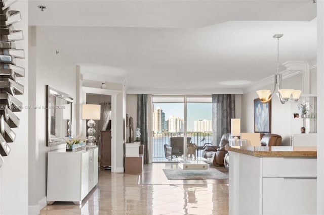 kitchen with crown molding, an inviting chandelier, expansive windows, open floor plan, and white cabinets