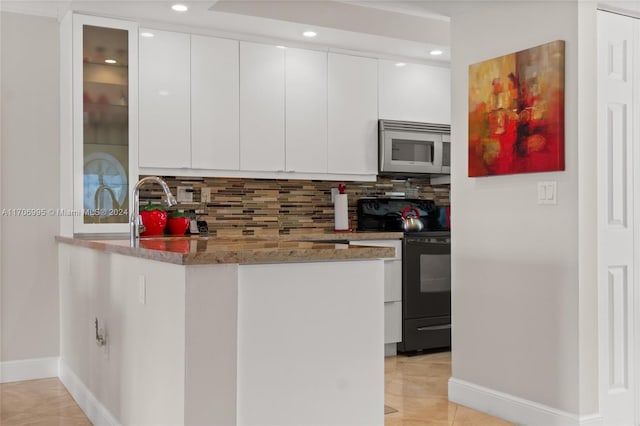 kitchen featuring tasteful backsplash, light stone counters, white cabinets, and black range with electric cooktop