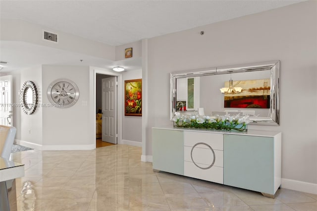 interior space featuring a textured ceiling and a chandelier