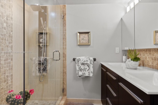 bathroom featuring tile patterned floors, vanity, an enclosed shower, and decorative backsplash