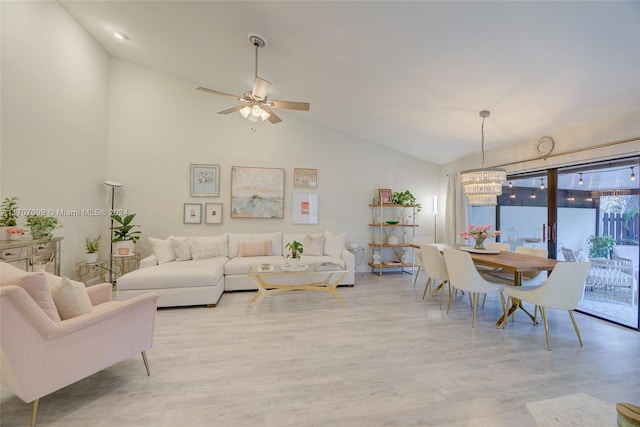 living room with light hardwood / wood-style flooring, high vaulted ceiling, and ceiling fan with notable chandelier