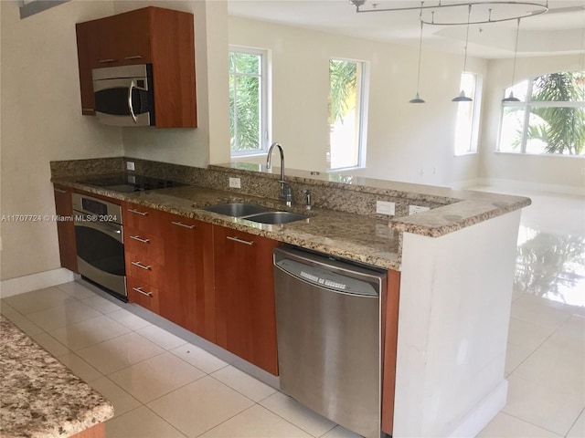 kitchen featuring pendant lighting, stainless steel appliances, light tile patterned floors, and sink