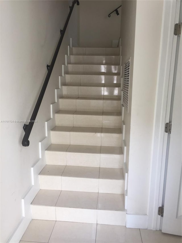 staircase featuring tile patterned floors