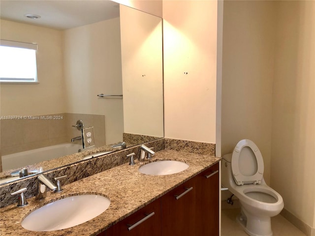 bathroom with tile patterned floors, vanity, a tub to relax in, and toilet