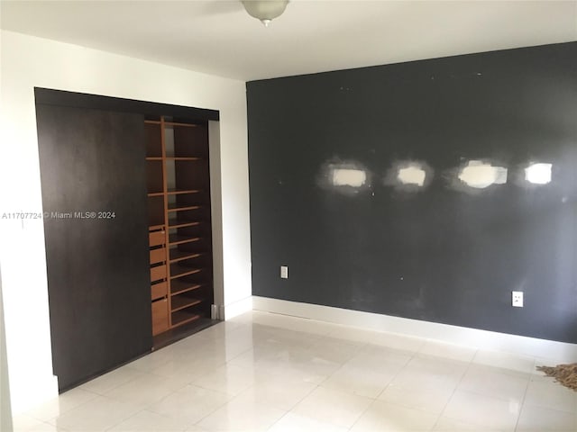 unfurnished bedroom featuring a closet and light tile patterned floors