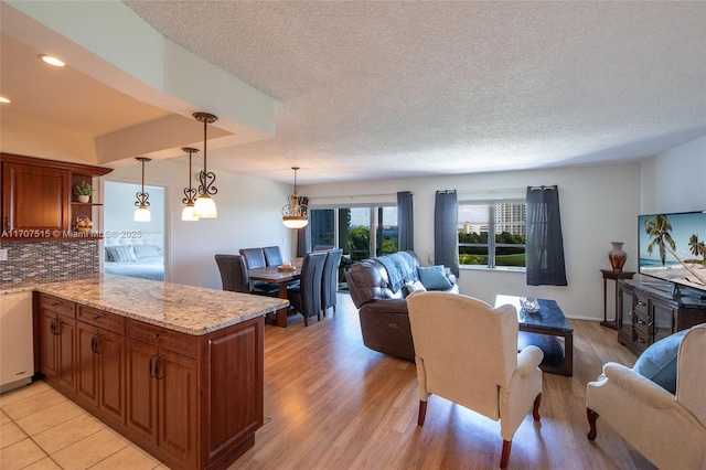 living area featuring light wood-type flooring, recessed lighting, and a textured ceiling