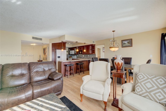 living room featuring light hardwood / wood-style floors and a textured ceiling