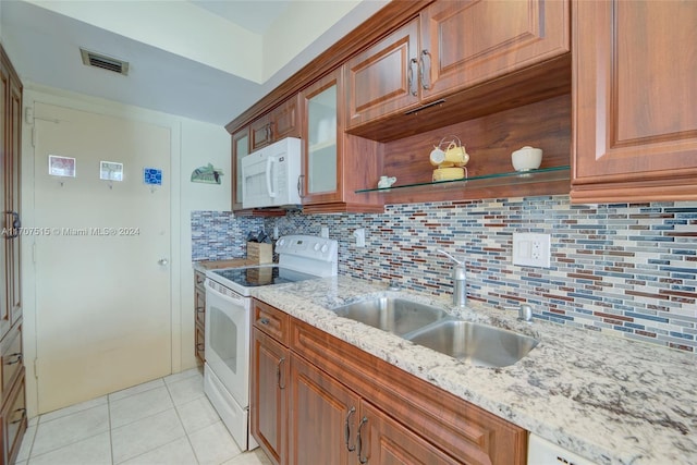 kitchen featuring tasteful backsplash, light stone counters, sink, and white appliances