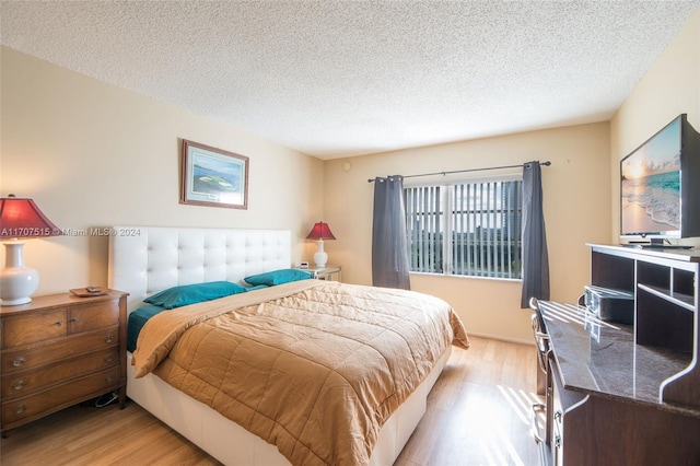 bedroom with light hardwood / wood-style flooring and a textured ceiling