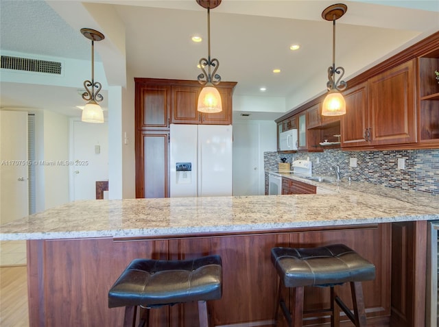 kitchen featuring visible vents, white appliances, a sink, open shelves, and backsplash