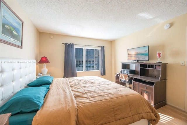 bedroom featuring hardwood / wood-style flooring and a textured ceiling