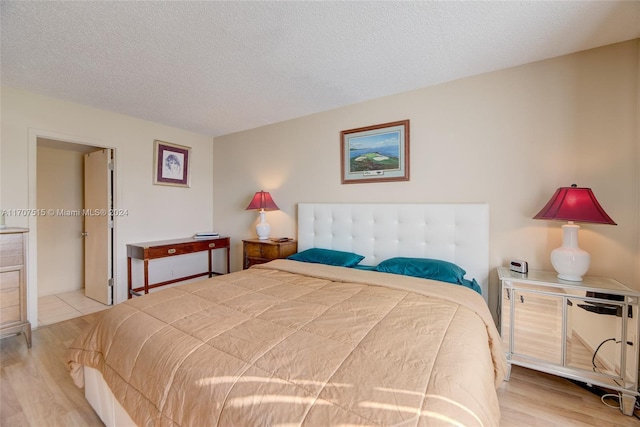 bedroom featuring light wood-type flooring and a textured ceiling