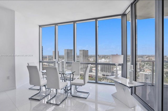 tiled dining room featuring floor to ceiling windows and plenty of natural light