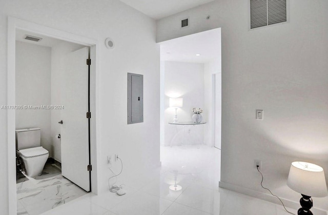 bathroom featuring electric panel and toilet