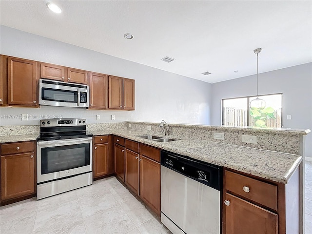 kitchen with appliances with stainless steel finishes, pendant lighting, sink, kitchen peninsula, and light stone countertops