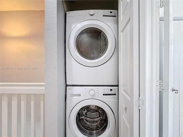 clothes washing area featuring stacked washer / dryer