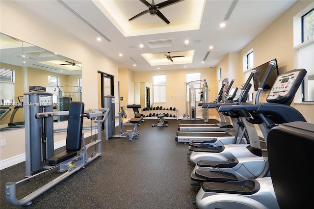 workout area featuring a tray ceiling and ceiling fan