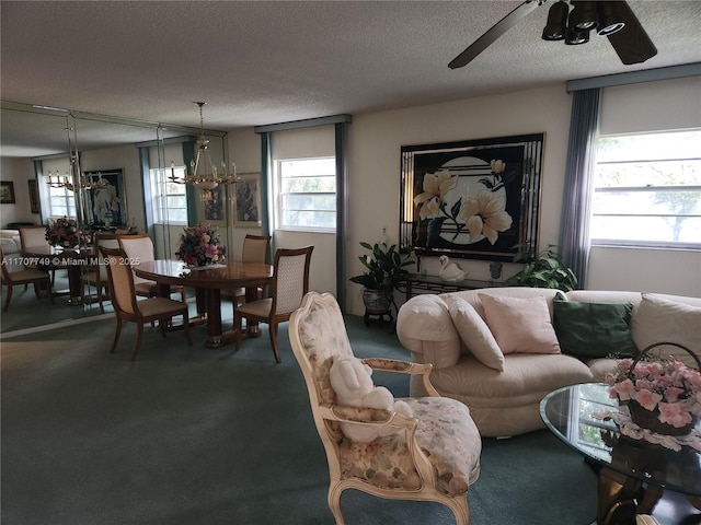 living room featuring carpet, ceiling fan with notable chandelier, and a textured ceiling