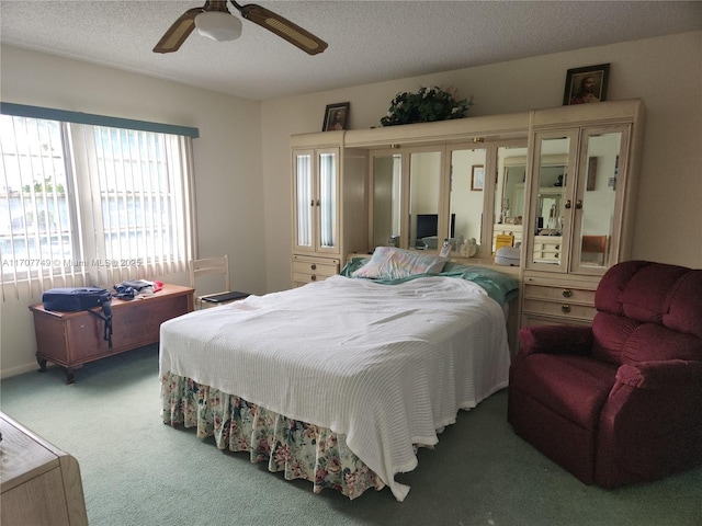 carpeted bedroom featuring ceiling fan and a textured ceiling