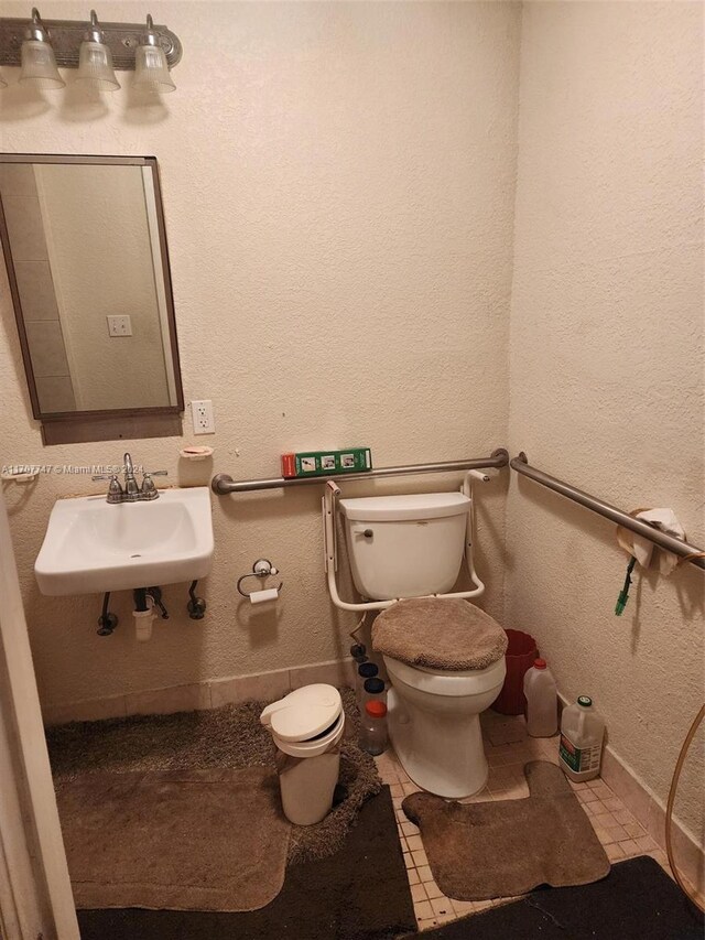 317 NW 3rd St, Deerfield Beach, FL 33441 - bathroom featuring tile patterned floors, sink, and toilet