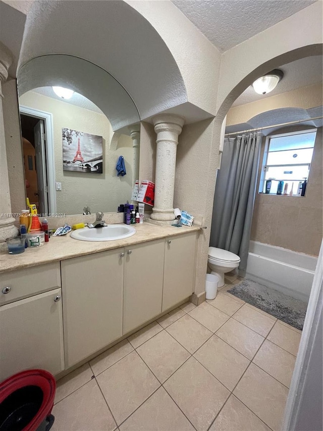 full bathroom featuring tile patterned flooring, vanity, toilet, and shower / bath combo with shower curtain