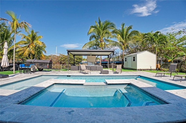 view of swimming pool featuring an in ground hot tub and a storage shed